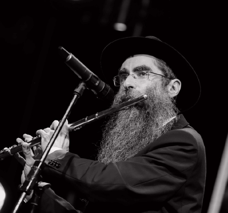 הרב לב לייבמן מנגן בחליל על הבמה